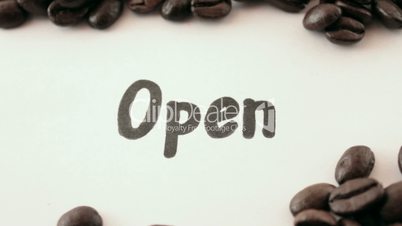 open.  written on white under coffee