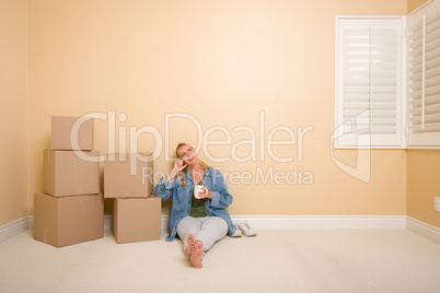 Happy Woman Relaxing Next to Boxes on Floor with Cup