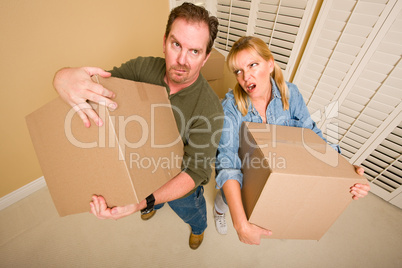Exhausted Couple Holding Moving Boxes