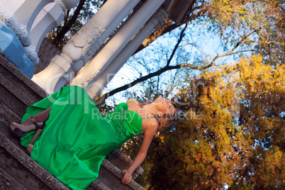 Beauty woman in green clothes sit on stair