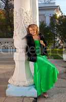 woman in green and fur coat stand near column