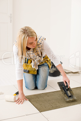 Home improvement, renovation - handywoman laying tile