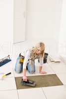 Home improvement, renovation - handywoman laying tile