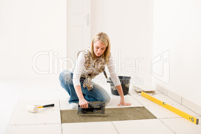 Home improvement, renovation - handywoman laying tile