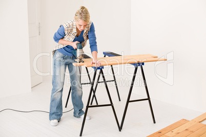 Home improvement - handywoman cutting wooden floor