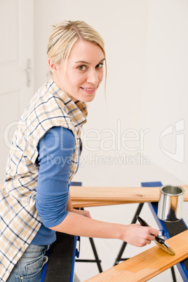 Home improvement - handywoman painting wooden plank