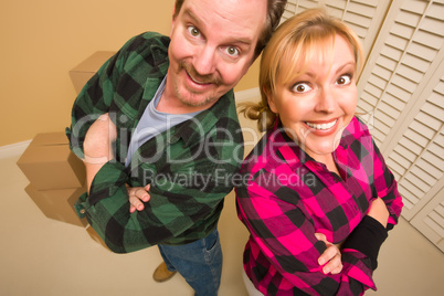 Proud Goofy Couple and Moving Boxes in Empty Room