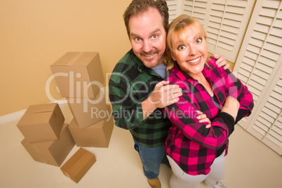Proud Goofy Couple and Moving Boxes in Empty Room