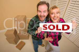 Goofy Couple Holding Sold Sign Surrounded by Boxes