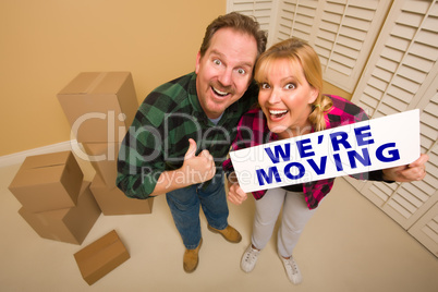 Goofy Couple Holding We're Moving Sign Surrounded by Boxes