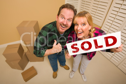 Goofy Couple Holding Sold Sign Surrounded by Boxes