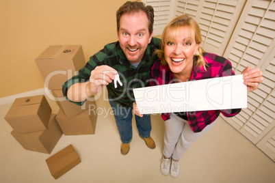 Goofy Couple Holding Keys and Blank Sign Surrounded by Boxes