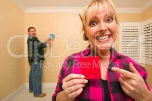 Couple Comparing Paint Colors in Empty Room