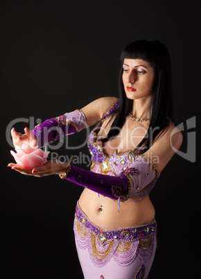 Woman in arabian costume look at rose candle