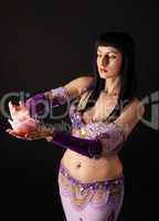 Woman in arabian costume look at rose candle
