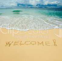 welcome written in a sandy tropical beach