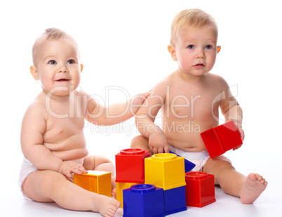 Two children play with building bricks