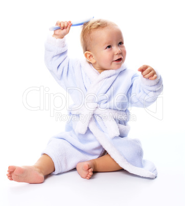 Cute child in bathrobe with comb