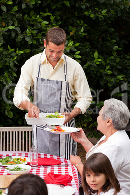 Man serving his mother at the table