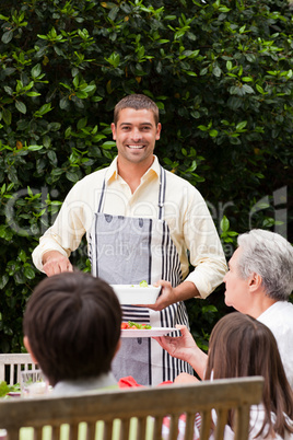 Man serving his mother at the table