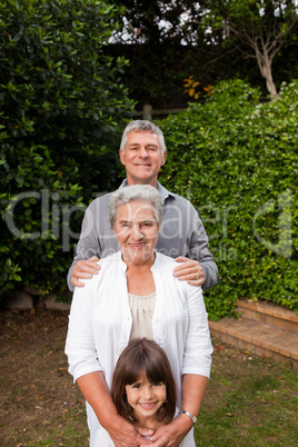 Grandparents with their granddaughter looking at the camera