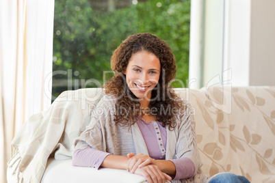 Smiling woman sitting on her sofa