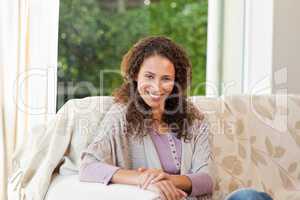Smiling woman sitting on her sofa