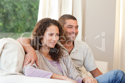 Couple watching tv in their living room at home