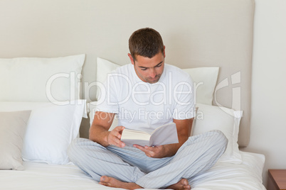 Man reading a book on the bed