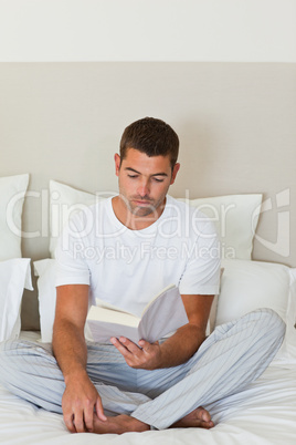 Man reading a book on the bed