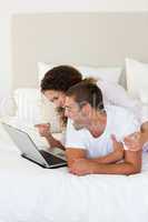 Lovely couple looking at their laptop