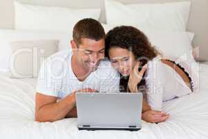 Lovely couple looking at their laptop