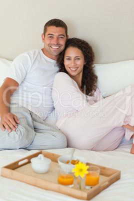 Couple having breakfast in their bed at home