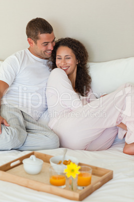 Couple having breakfast in their bed at home