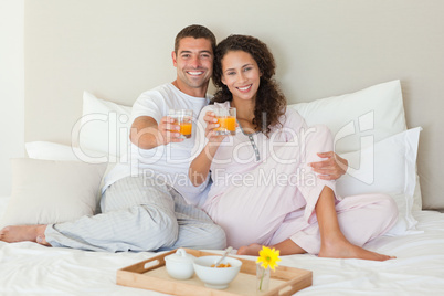 Couple having breakfast in their bed at home