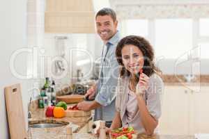 Woman eating while her husband is cooking