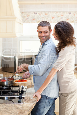 Woman hugging her husband while he is cooking