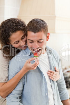 Lovers eating a strawberry in their kitchen