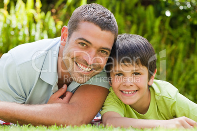 Father with his son lying down in the garden