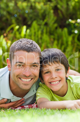 Father with his son lying down in the garden