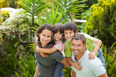 Mother and father giving children a piggyback