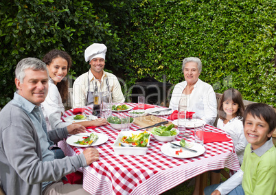 Happy family eating in the garden