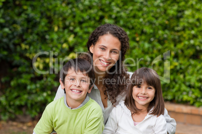 Mother with their children looking at the camera in the garden