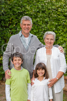 Grandparents with their children looking at the camera in the ga