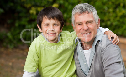 Grandfather with his grandson looking at the camera in the garde