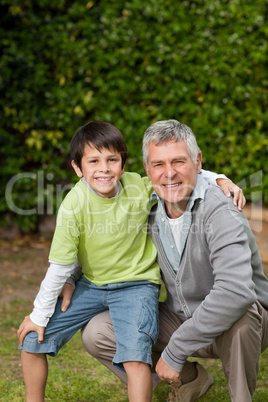 Grandfather with his grandson looking at the camera in the garde