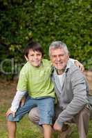 Grandfather with his grandson looking at the camera in the garde