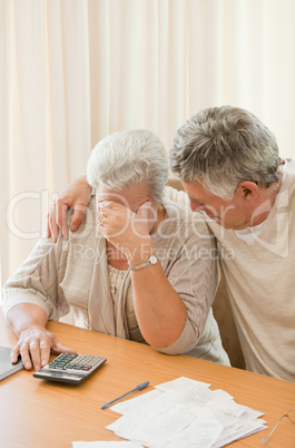 Sad mature couple calculating their domestic bills