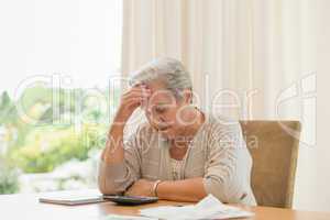 Retired woman calculating her domestic bills