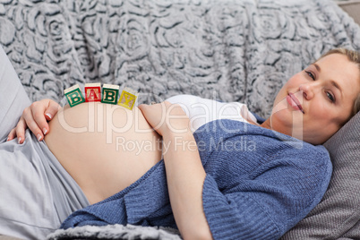 Pregnant young woman with cubes on her belly